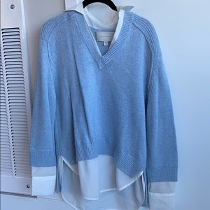 Blue sweater with a white button down attached.